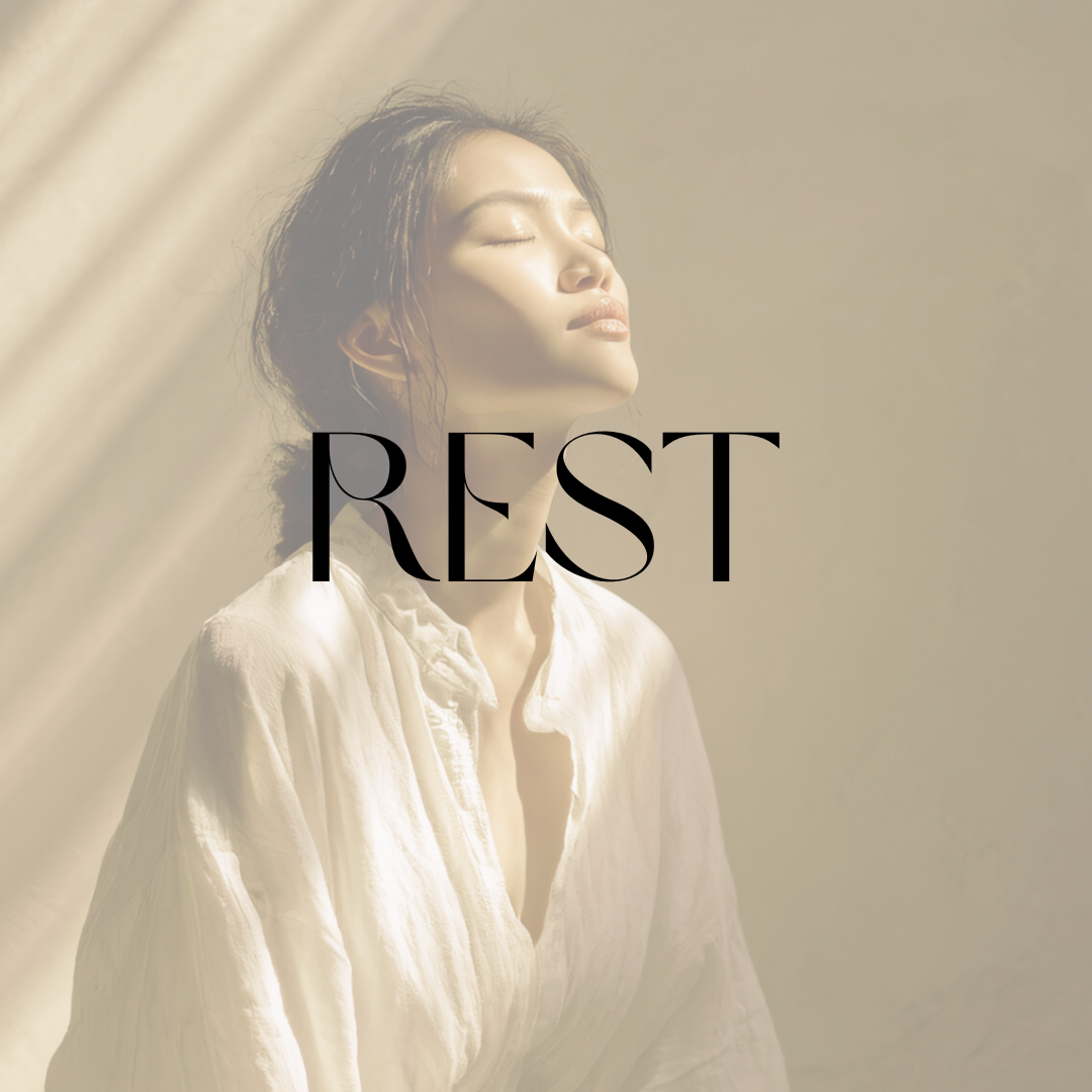 Woman resting with eyes closed in warm sunlight with the word “Rest.”