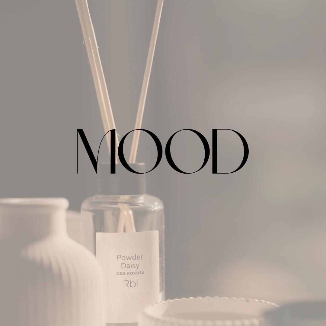 Soft-toned diffuser bottle and decor with the word “Mood.”